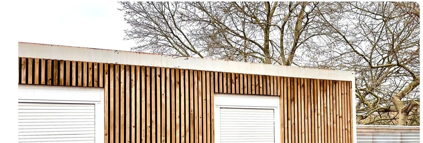 Same building after Eastrada softwash — timber cladding restored to clean natural finish